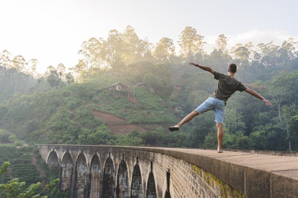 reckless man walking on the edge of the nine-arches bridge in Sri Lanka